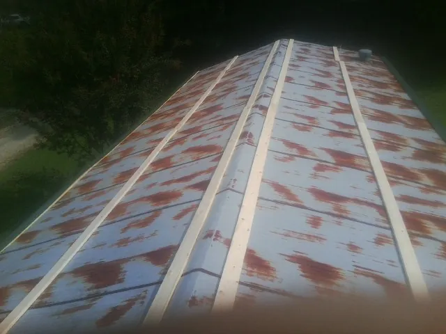 Rusted metal roof panels with new wood purlins before replacement — Storm Damage Roof Repair in Potterville by Roofing Brothers